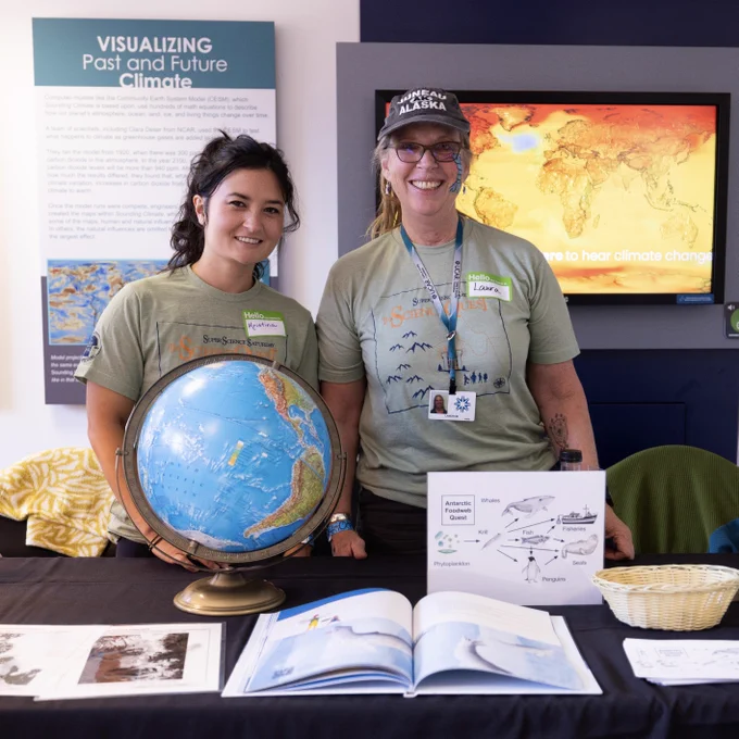 Two staff members standing behind a table and smiling at the camera.