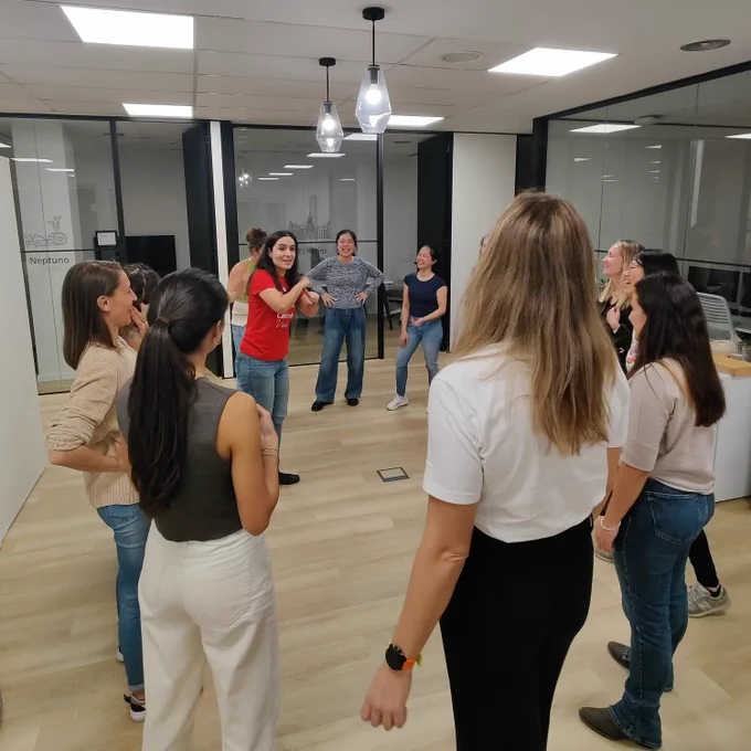 Foto de las participantes durante una de las dinámicas, de pie y formando un círculo.
