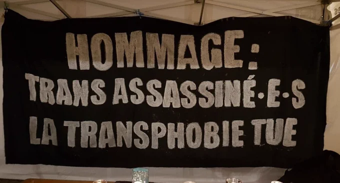 Une bannière : "Hommage : trans assassiné.e.s la transphobie tue"