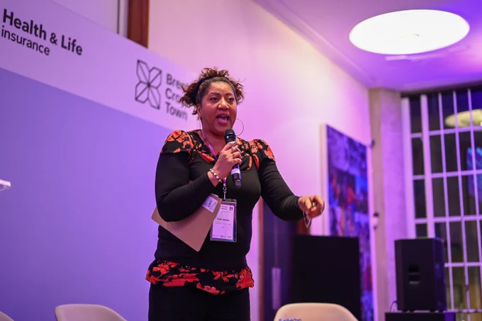 BBC Presenter Trish Adudu on stage addressing delegates