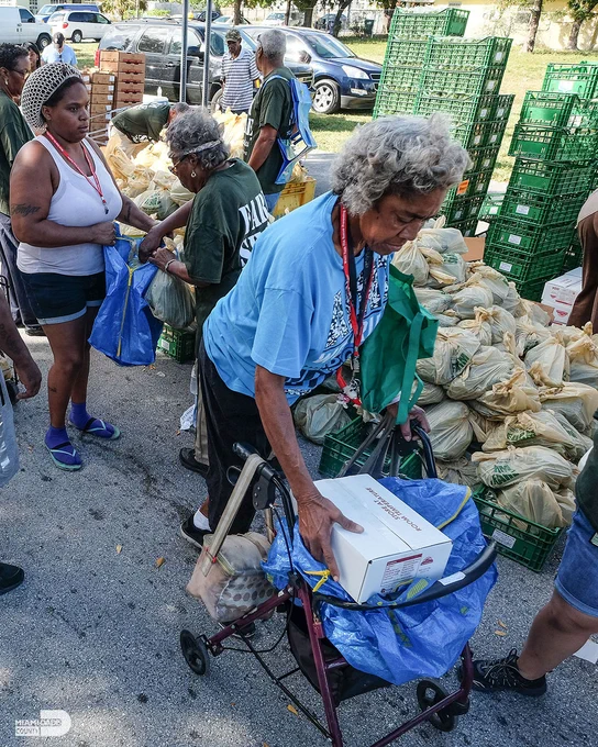 A line of people waiting to pickup food.
