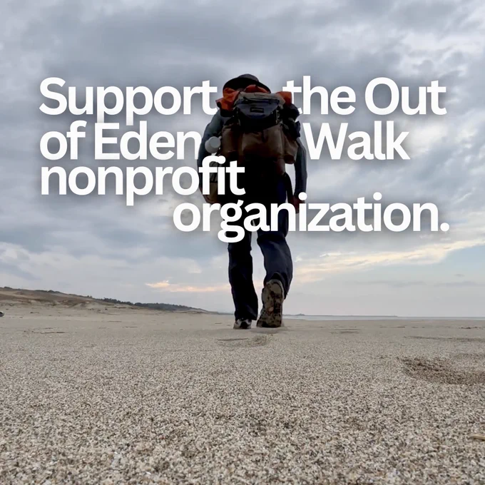 A person walks along a beach. He is carrying a backpack and wearing hiking clothing. The sky is overcast. Text overlaid on the image says, "Support the Out of Eden Walk nonprofit organization." 