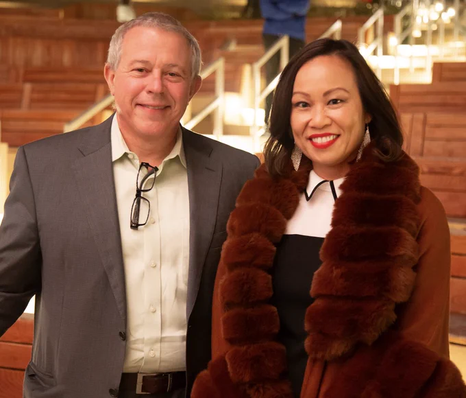 Left to right: Bob Continetti and Mai Nguyen pose in front of lighted benches at the Epstein Family Amphitheater.
