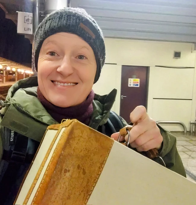 Person carrying a vintage suitcase. 