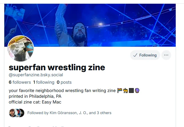 image of bksy header for superfan zine, photo of cat on the cover of a zine and roman reigns in the background. 