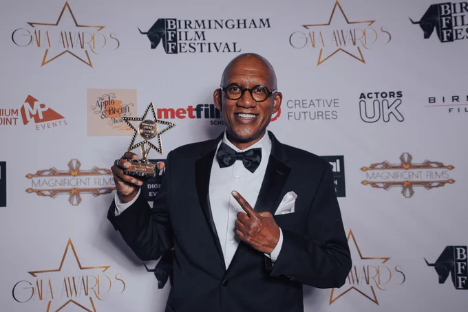 executive producer herb jackson jr holding the audience vote award trophy at the birmingham film festival. november 16 2024