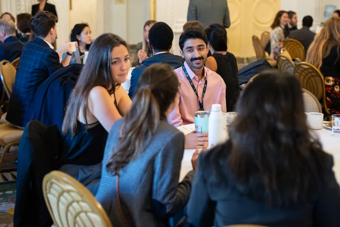 A group of Science Fellows listening to someone talking at a table