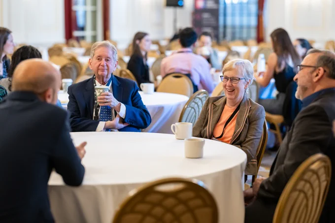 A group of Science Fellows at a table with hot drinks