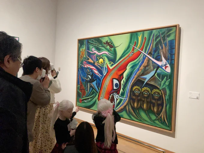 川崎市岡本太郎美術館の鑑賞会で。絵の前で、「レティッサオンハンド」を使って見ているひとたち。