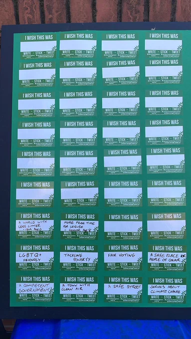 Board with a number of stickers saying “I wish this was” on it with free space to write ideas for a better world