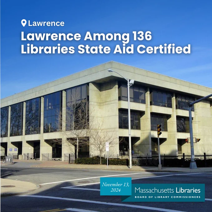 Exterior and facade of Lawrence Public Library angled at right corner, on a bright blue sky day.
