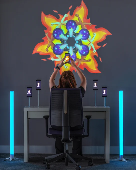 A person lifts a phone above their head next to phones displaying candle emojies