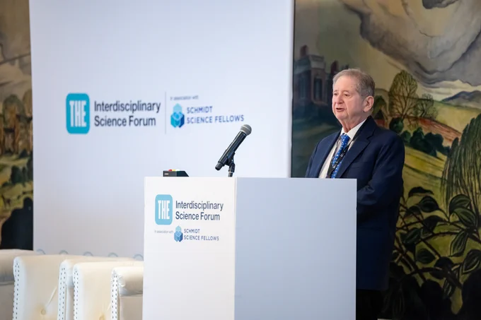 Stu Feldman at a lectern giving a speech, with Interdisciplinary Science Forum branding