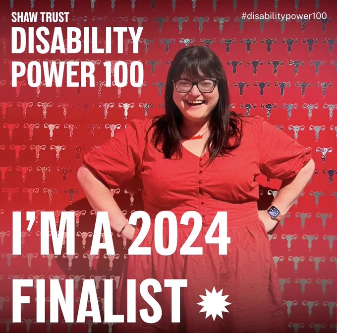 Shaw Trust Disability Power 100; #DisabilityPower100; I’m a Finalist 2024 Image of Chella Quint in a red dress posing in front of a red wall of silver uterus stamps.