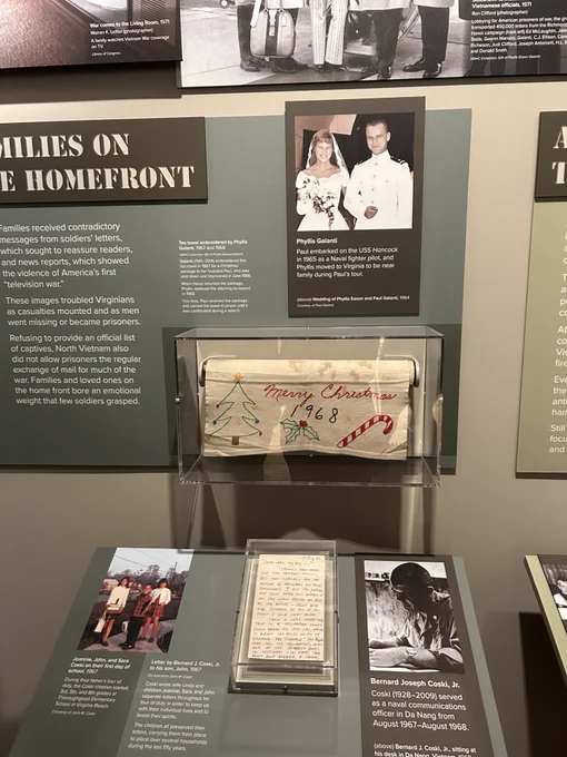 Display case from exhibit - wedding photo, tapestry that says merry christmas