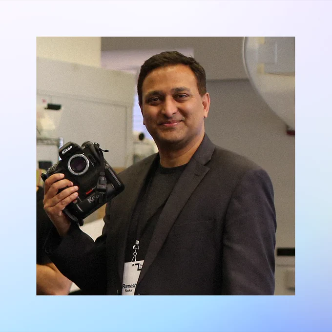 Ramesh Raskar, wearing a dark blazer and holding a Nikon camera. Credit: Paula Aguilera