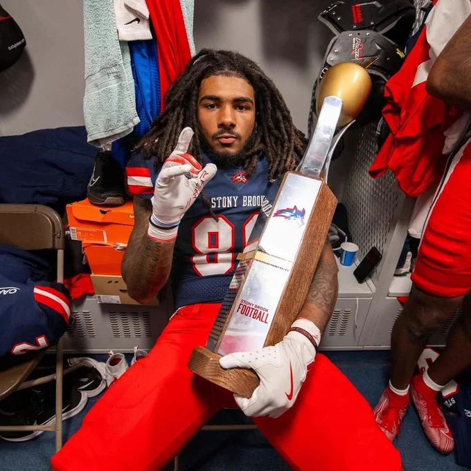 Former Wi-Hi football player Jayce Freeman holding trophy at Stony Brook College