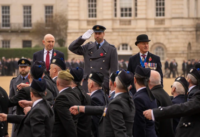 Secretary of State for Defence, The Rt Hon John Healey MP (left) and HRH The Prince of Wales (centre) on the podium, taking the salute from Veterans as they march past Horse Guards Parade  at the the National Service of Remembrance.
