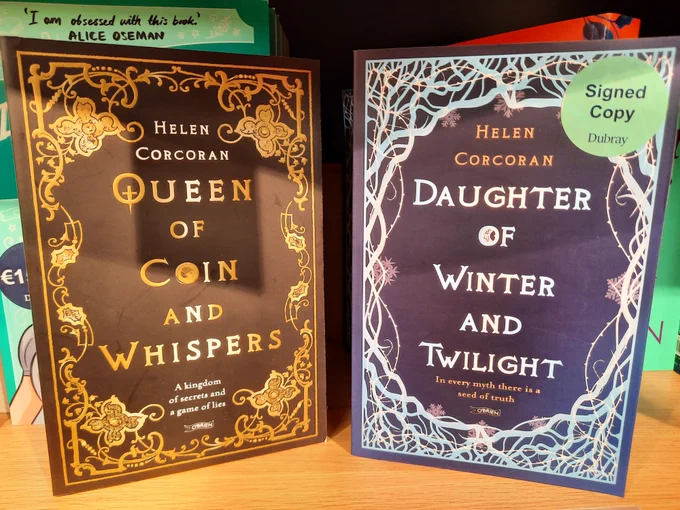 Two books sitting on a shelf at Dubray Books on Henry Street, Dublin. "Queen of Coin and Whispers" and "Daughter of Winter and Twilight". Both by Helen Corcoran. 