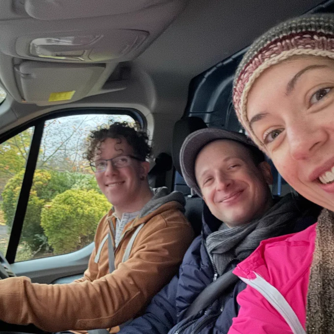 A selfie of Nick, David and Hattie in the van ready to start a day of Kinder shows. All the team are smiling at camera. 