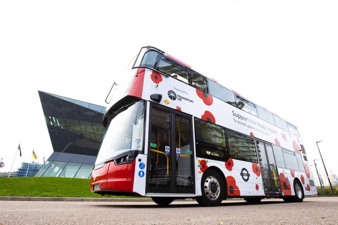 A photo facing upwards showing the Transport UK London Bus logos, with the Poppy Appeal livery on the side.