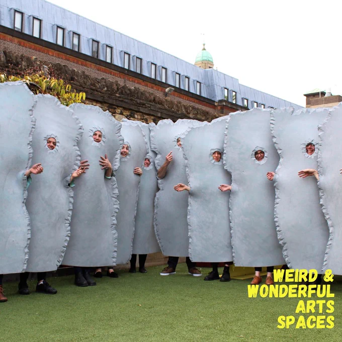 A group of people wearing grey stone costumes standing in a line in the garden at Chauffeurs Cottage.