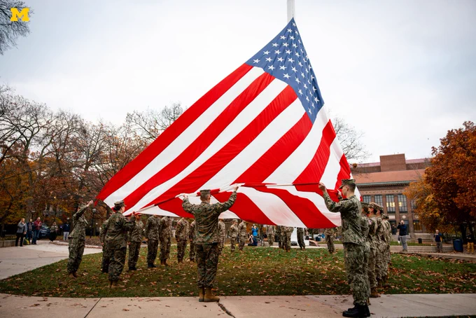 U-M ROTC members begin to raise the flag on the Diag flagpole.