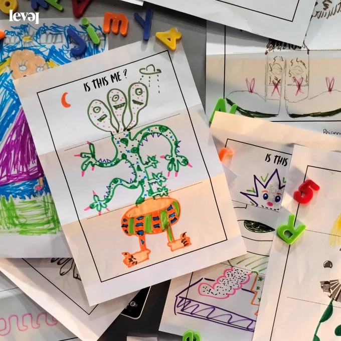 Lots of colourful drawings layered together on what looks like a fridge door. Alphabet and number magnets hold them on. The drawings are of fantastical creatures designed by people of all ages.