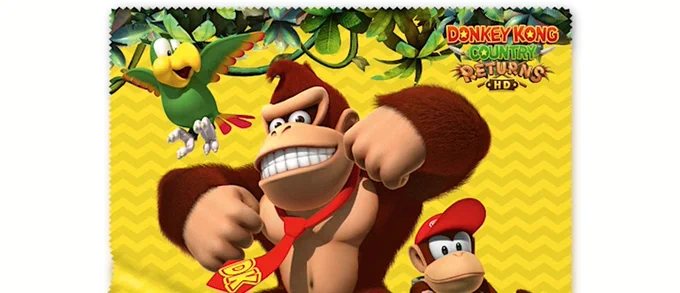 The Donkey Kong Country Returns HD Microfibre Cloth with renders of Donkey Kong, Diddy Kong, and Squawks the parrot against a yellow background with black zigzags and jungle vines hanging down across the top.