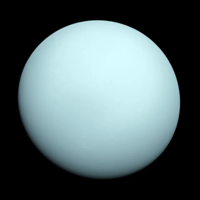 A pastel blue sphere with a very smooth surface is shown against the blackness of space. NASA’s Voyager 2 captured this image of Uranus while flying by the ice giant in 1986.
