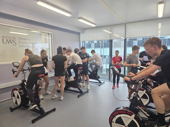 Local school pupils experiencing working in an extreme environment laboratory on watt bikes