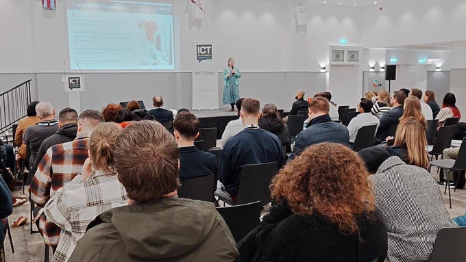 Margaret on stage giving a presentation at the ICT for Education conference. The slide being presented is the current demand for engineers on jobsites.