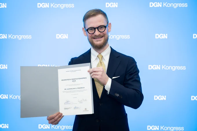 Dr. Maximilian U. Friedrich, Assistenzarzt und Wissenschaftler an der Neurologischen Klinik und Poliklinik des UKW, erhielt auf dem Jahreskongress der Deutschen Gesellschaft für Neurologie (DGN) in Berlin den mit 50.000 Euro dotierten „NeuroTech-Innovationspreis“ der Manfred und Ursula Müller-Stiftung und der DGN. © DGN/Claudius Pflug