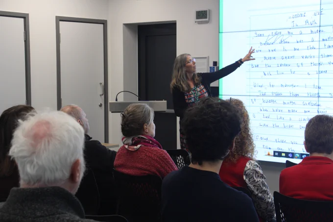 Presentation being delivered by Sarah-Jayne Ainsworth, who is pointing at Jack Clemo's handwriting displayed on a large screen.