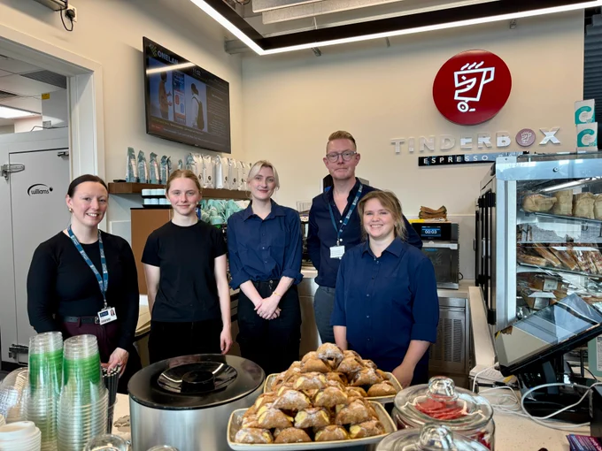 Five people stand behind the counter at the new Tinderbox in the Adam Smith Building 