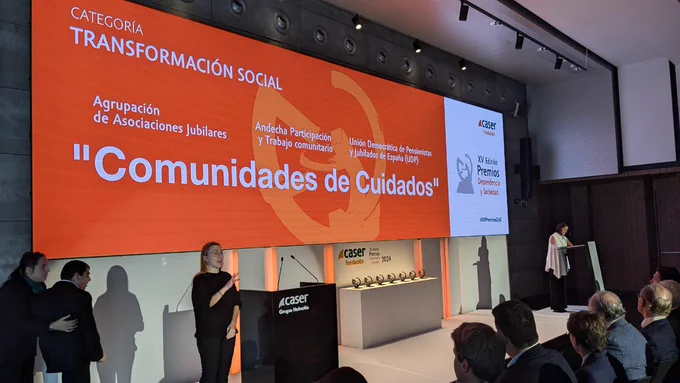Imagen del acto de entrega del XV Premio Dependecia y Sociedad de la Fundación CASER. Un cartel presenta la categoría "Transformación Social" junto con el nombre de las tres entidades ganadoras Asociación Jubilares, Andecha Participación y Trabajo comunitario y la Unión Democrática de Pensionistas y Jubilados de España (UDP)