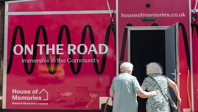 Two visitors step inside the front door of our mobile immersive touring museum