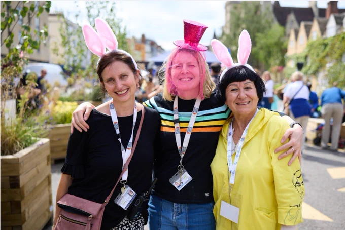 Three colleagues wearing costumes on Broad Street for Alice's day. 