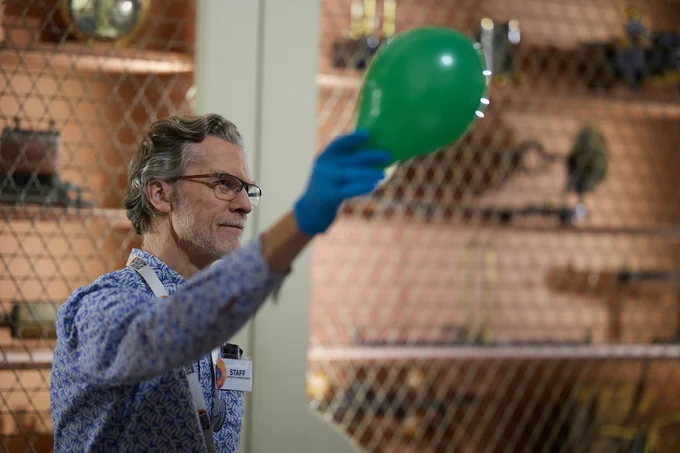 Learning team member holding a green balloon as part of a science demonstration 