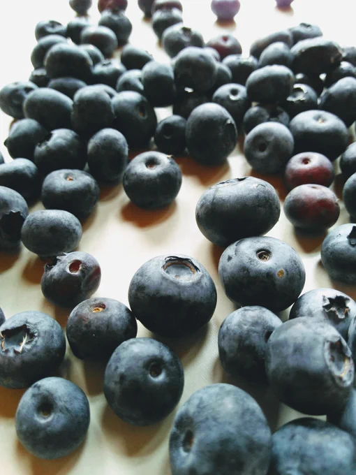 Fresh blueberries rolling on a tabletop. 