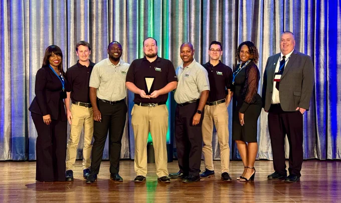 Rush University College of Nursing students and faculty members posing on stage at a conference after being named one of the Best Schools for Men in Nursing by the American Association for Men in Nursing.
