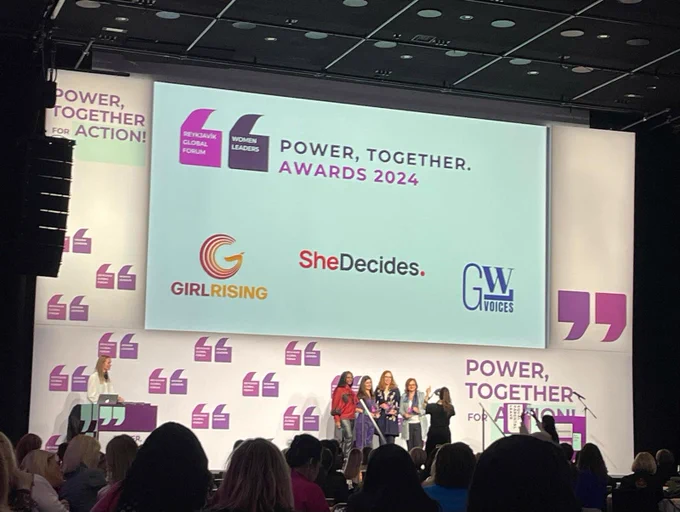 Group of individuals on a stage at the Power, Together Awards 2024. The background features the event's bright purple and white branding.