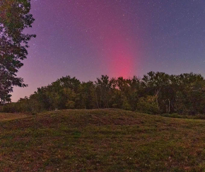 A large American Indian Mound with red northern lights and stars dancing above. Photo taken in October 2024 by Brian Gibbs / NPS.  
