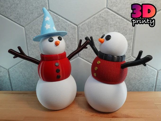 Photo of two giant 3D printed snowpeople. The print on the right is wearing a light blue pointy hat with white stars.