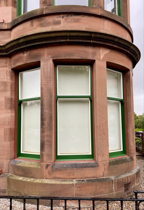 This is a classic Glasgow tenement corner bay with lovingly overhauled sash & case windows with rather smart red sand mastic and repainted a handsome shade of Corporation Green