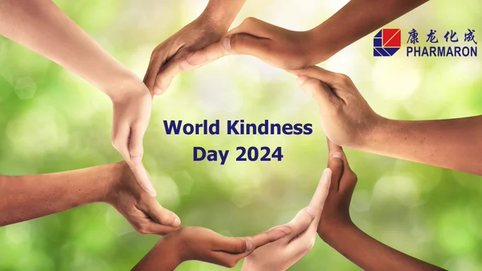 Hands of diverse individuals form a heart shape against a soft green background, symbolizing unity for World Kindness Day 2024.