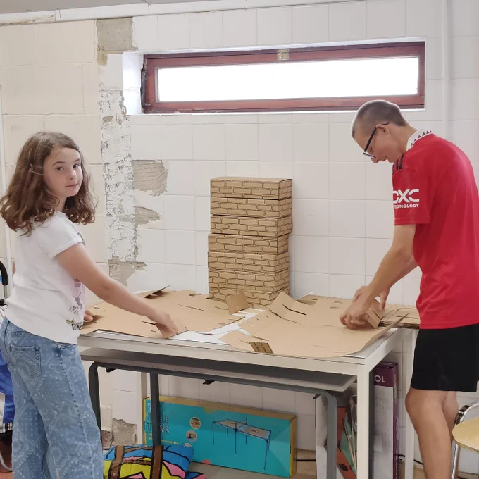 Two players building cadboard building blocks.