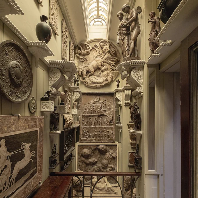 In the narrow Lobby to the Breakfast Room, the walls - from floor to ceiling - are adorned with friezes and casts, with many objects on pedestals.