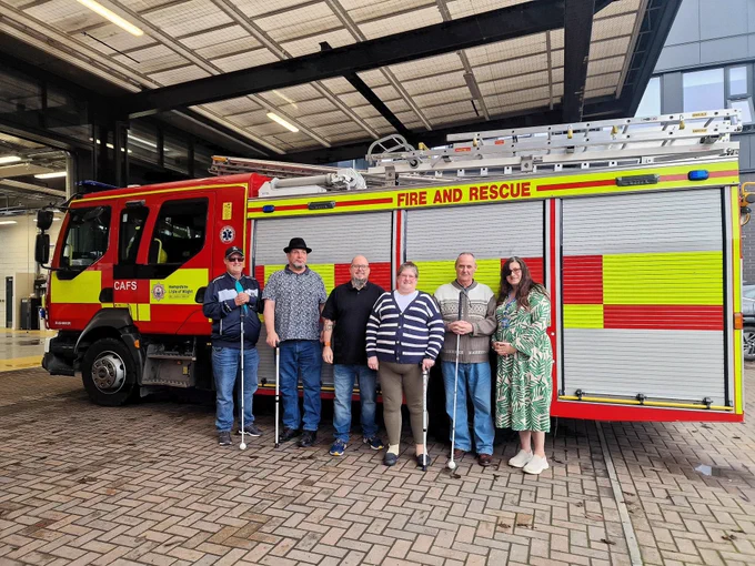 6 People standing in front of a fire truck