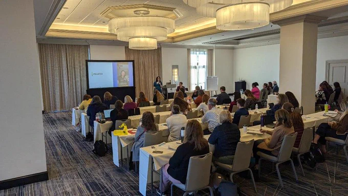 A room full of library marketers listen attentively to NoveList's Caleigh Haworth and Angela Hursh discuss collection marketing at the pre-conference session on Tuesday, November 12.